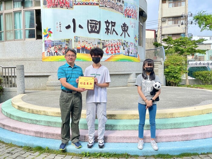 東新國小校長和2位學生於升旗活動進行頒獎