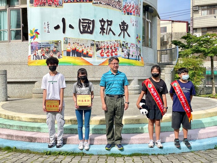 東新國小校長和4位學生於升旗活動進行頒獎