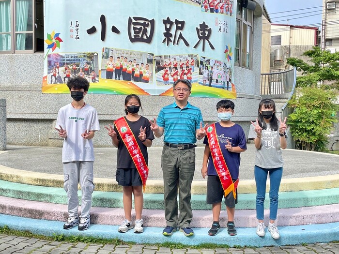 東新國小校長和4位學生於升旗活動進行頒獎